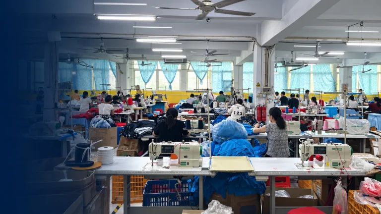Sewing floor at Vista Clothing factory with rows of industrial sewing machines producing custom sportswear