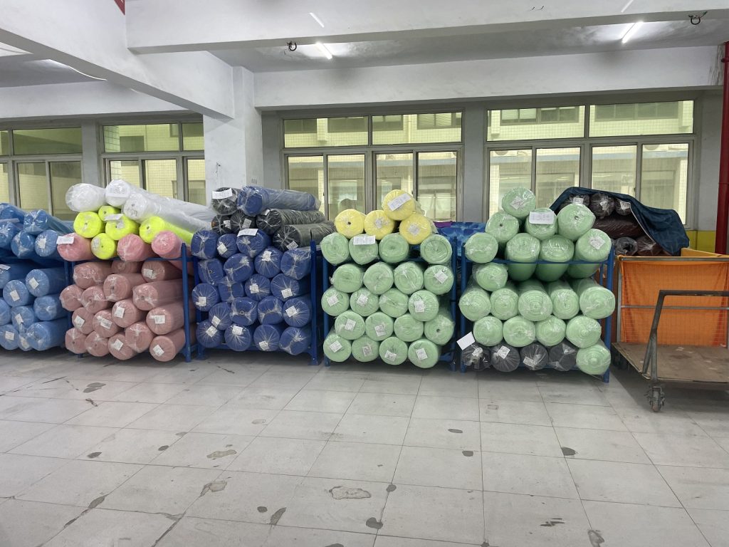 Fabric warehouse with stocked fabric rolls at Vista Clothing factory