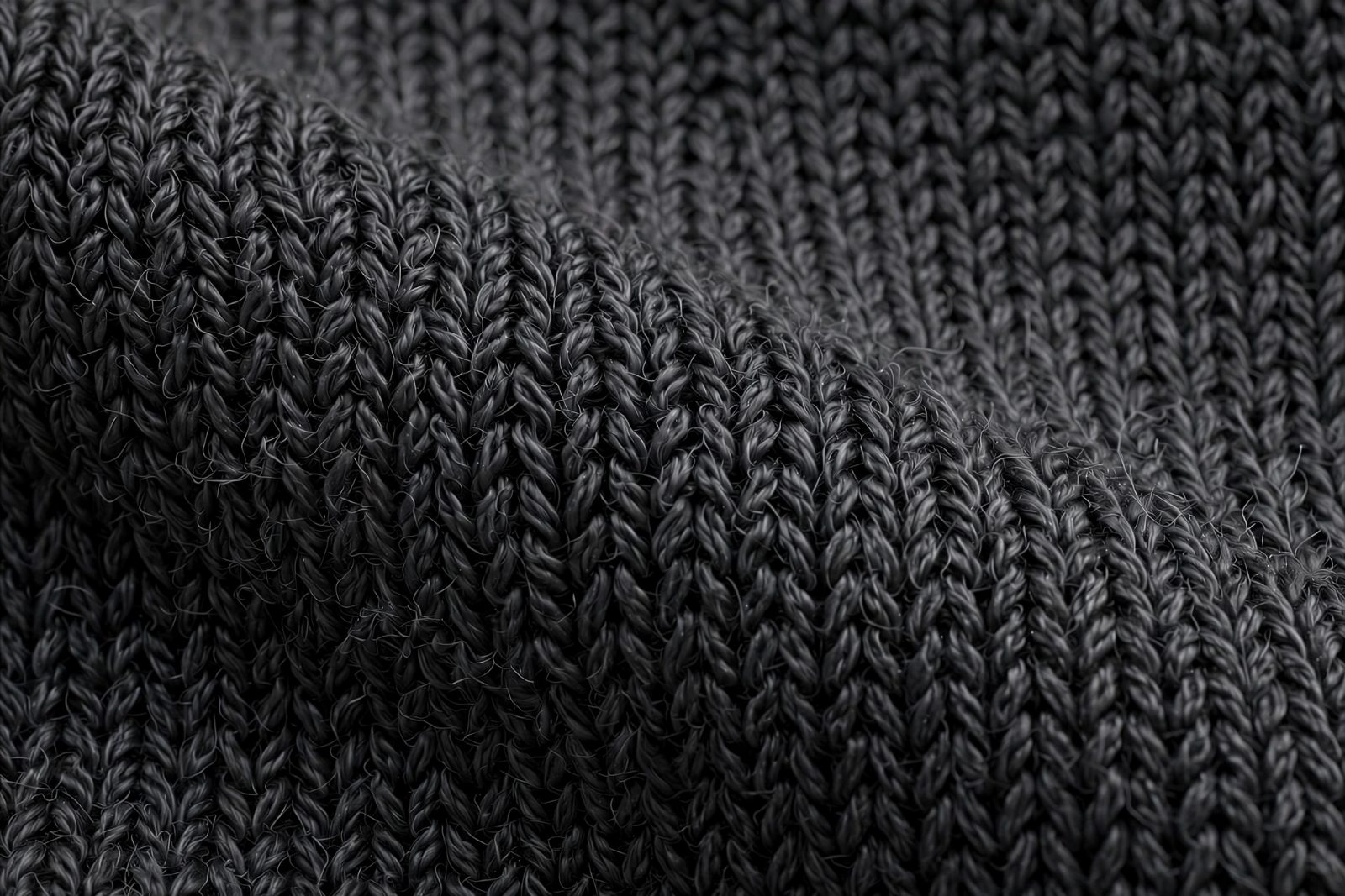 Macro view of dense charcoal stretch-knit fabric showing the tight knit-loop structure that keeps leggings opaque (concept illustration)